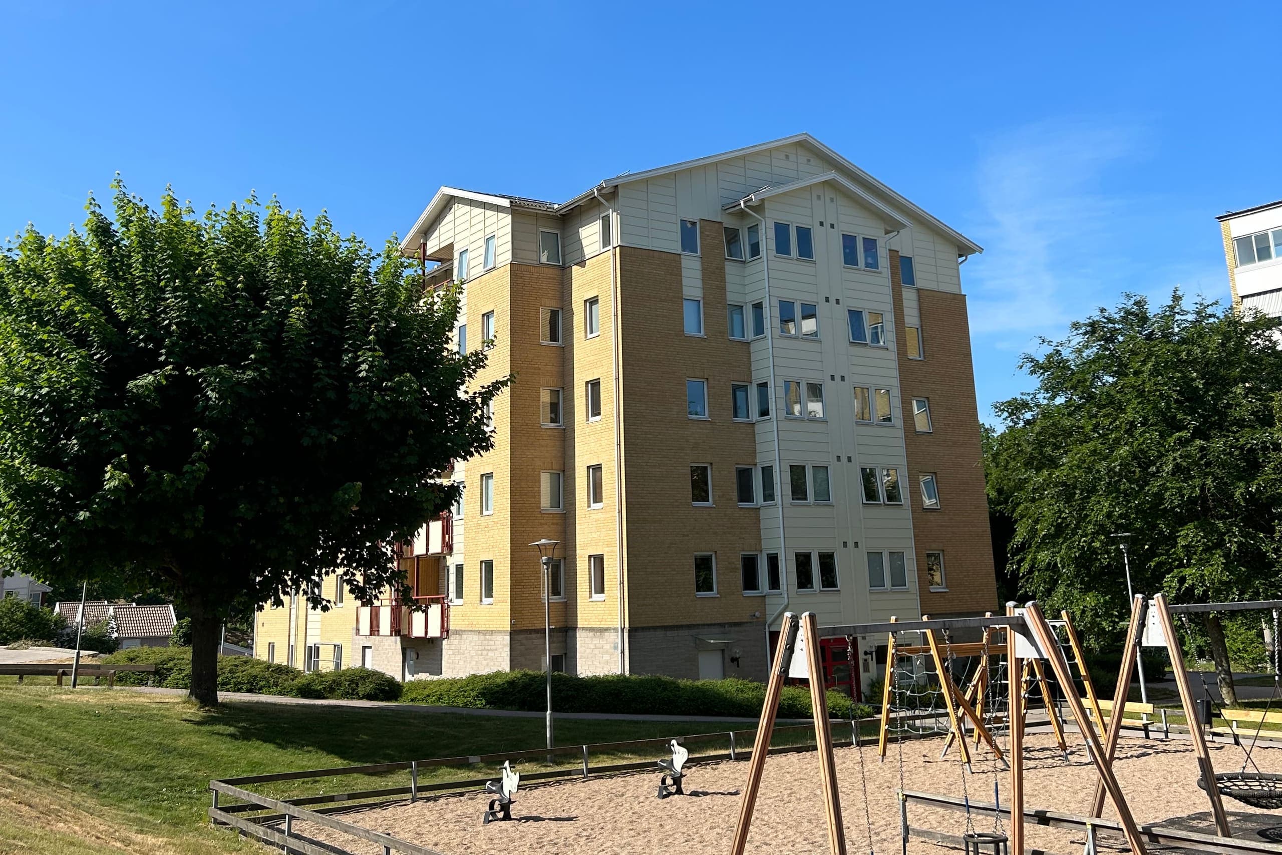 Gult tegelhus i fem våningar med lekplats framför, Musseronvägen i Karlshamn.