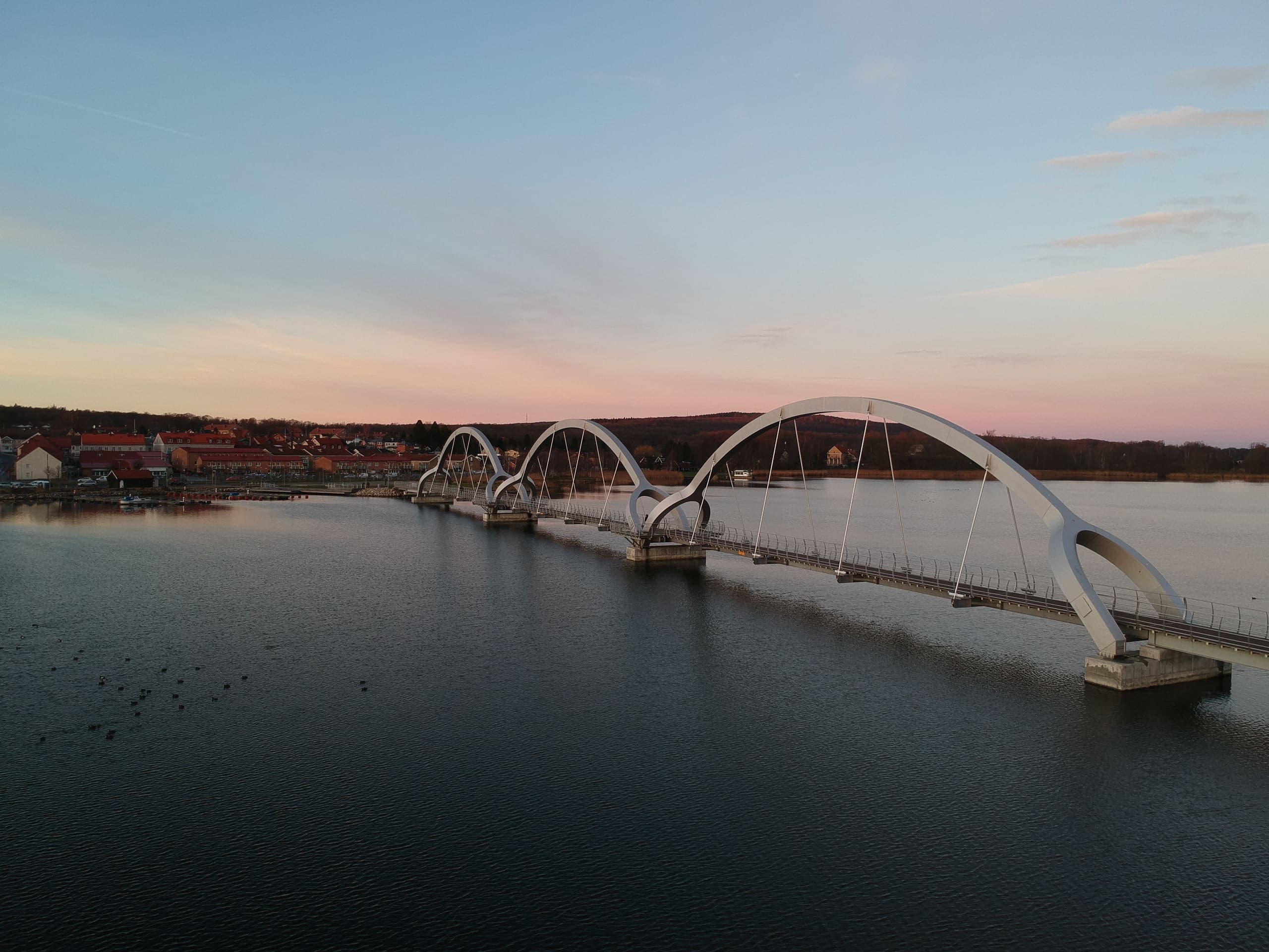 Sölvesborgsbron över Sölvesborgsviken i solnedgången, med bostadshus på andra sidan vattnet.